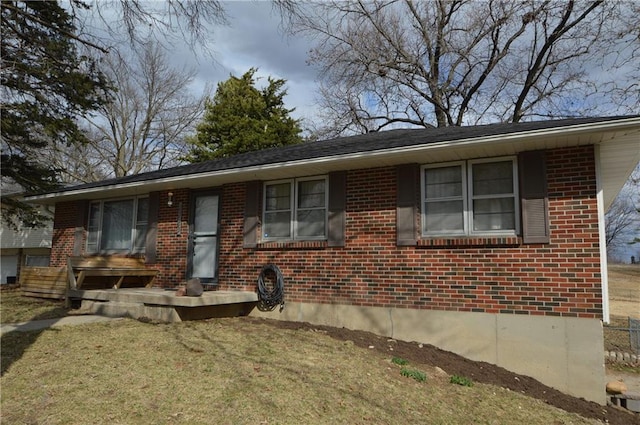 view of front of property featuring brick siding and a front lawn