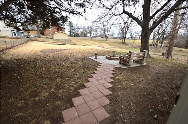 view of yard featuring an outdoor fire pit, fence, and a patio