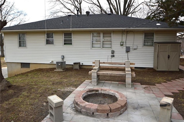 back of house with a patio area, a shingled roof, and a fire pit