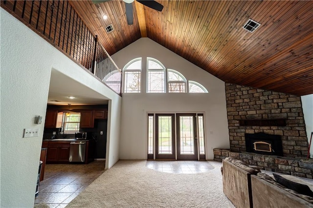 living area with a wealth of natural light, a ceiling fan, and visible vents