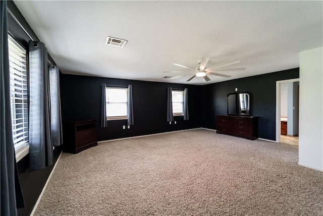 unfurnished bedroom featuring visible vents, carpet flooring, baseboards, and a ceiling fan