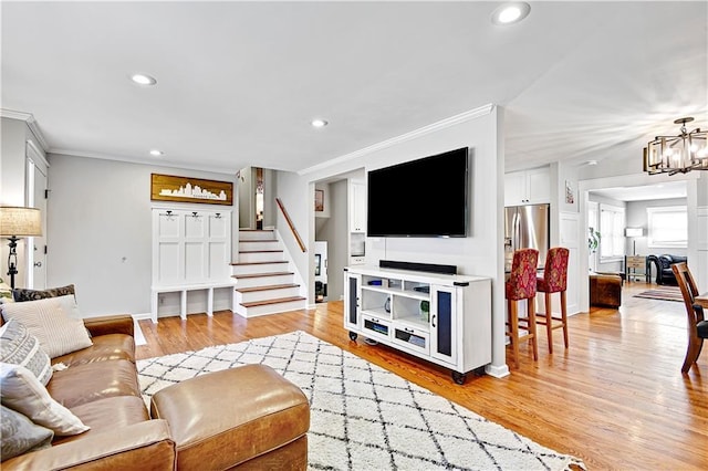 living room with light wood finished floors, stairs, ornamental molding, recessed lighting, and an inviting chandelier