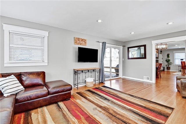 living room featuring visible vents, a notable chandelier, wood finished floors, recessed lighting, and baseboards