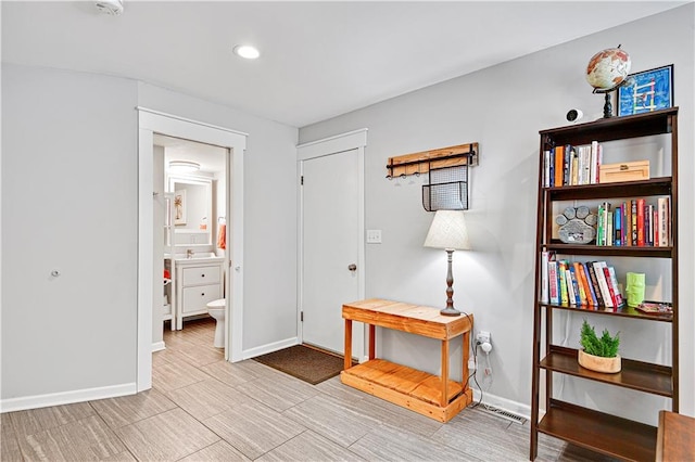 interior space featuring visible vents, ensuite bath, and baseboards