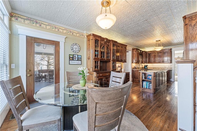 dining area with an ornate ceiling, ornamental molding, and dark wood finished floors