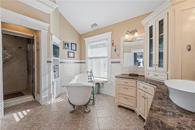 full bath featuring vanity, a wainscoted wall, visible vents, a freestanding tub, and a stall shower