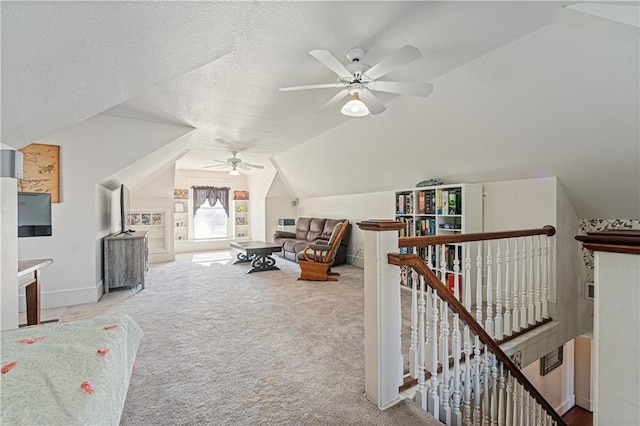 interior space featuring an upstairs landing, carpet, lofted ceiling, and a textured ceiling