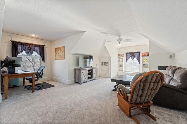 carpeted living room with a textured ceiling, a healthy amount of sunlight, and vaulted ceiling