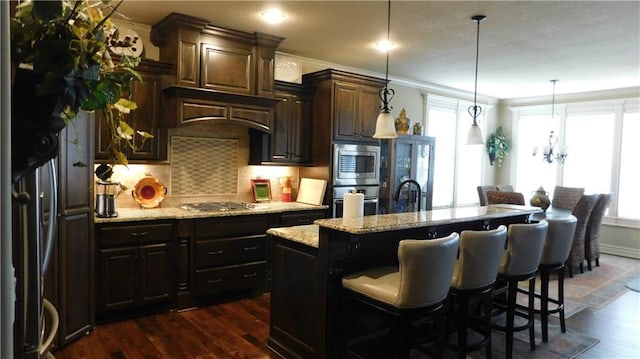 kitchen with a wealth of natural light, stainless steel appliances, dark wood-style floors, and ornamental molding