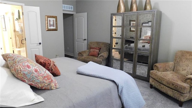 carpeted bedroom featuring visible vents and ensuite bathroom