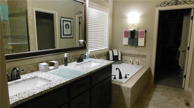 bathroom with a walk in closet, double vanity, a bath, and a sink