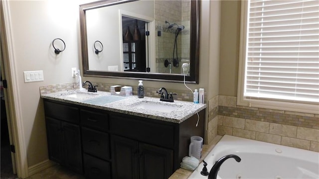 full bathroom with double vanity, a whirlpool tub, and a sink