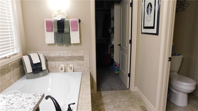 full bath with a spacious closet, toilet, and a garden tub