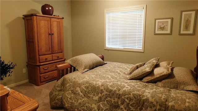 bedroom featuring light colored carpet and baseboards