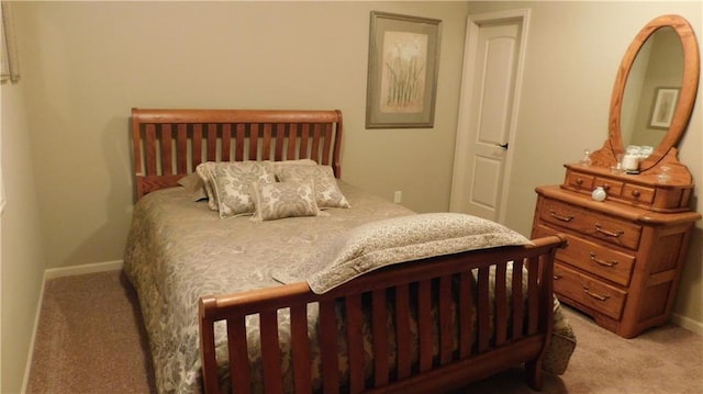 bedroom with baseboards and light colored carpet