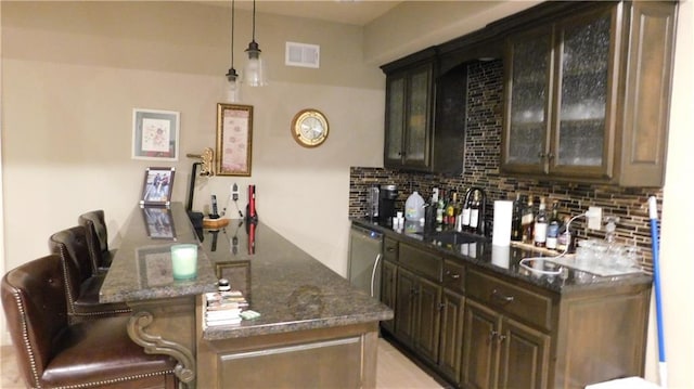 bar with a sink, visible vents, dishwasher, and decorative backsplash