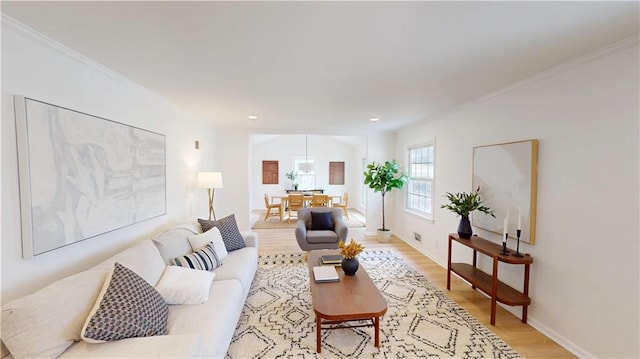 living area with light wood-style floors, recessed lighting, ornamental molding, and baseboards