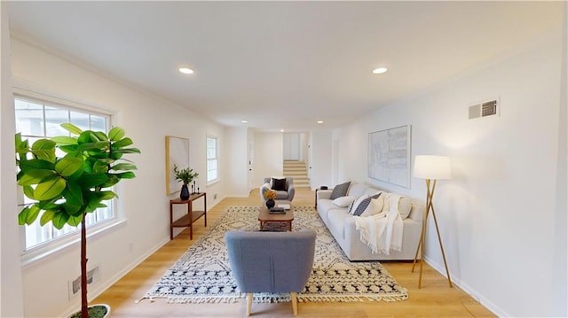 living area with light wood finished floors, recessed lighting, visible vents, baseboards, and stairs