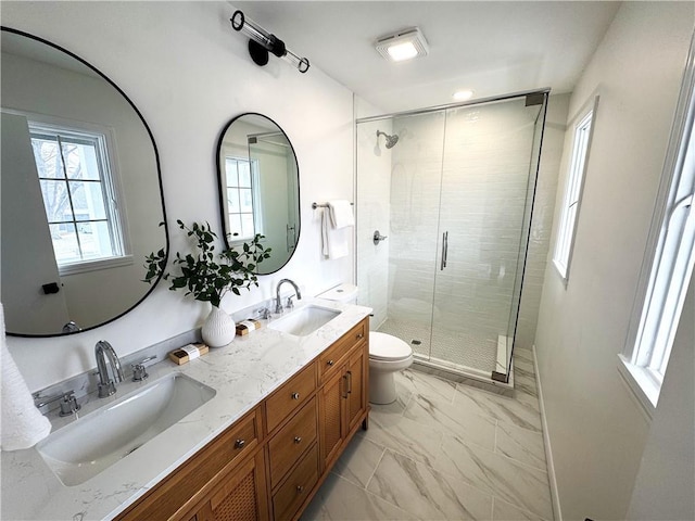 bathroom featuring toilet, marble finish floor, a sink, and a stall shower