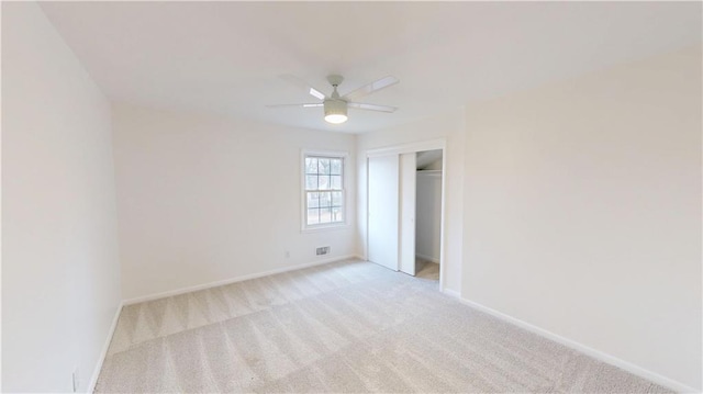 unfurnished bedroom with a closet, visible vents, a ceiling fan, light carpet, and baseboards