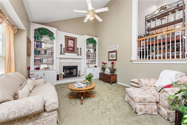 living area with visible vents, a fireplace with raised hearth, carpet floors, baseboards, and ceiling fan