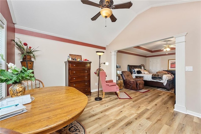 interior space featuring light wood finished floors, baseboards, lofted ceiling, ornamental molding, and decorative columns