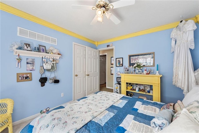 carpeted bedroom with baseboards, a ceiling fan, visible vents, and ornamental molding