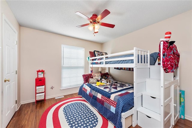 bedroom featuring ceiling fan, baseboards, a textured ceiling, and wood finished floors