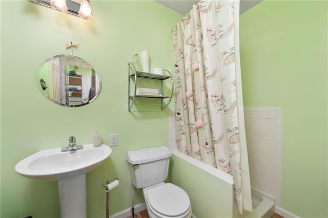 bathroom featuring a sink, baseboards, a shower with curtain, and toilet