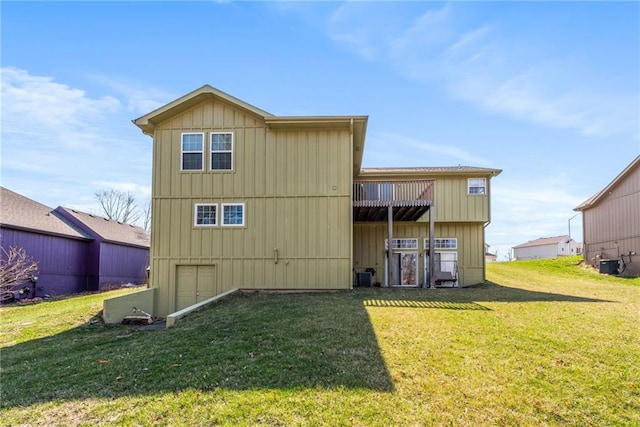 rear view of house featuring a lawn, board and batten siding, and central AC