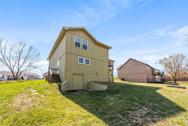 back of property featuring a lawn and board and batten siding