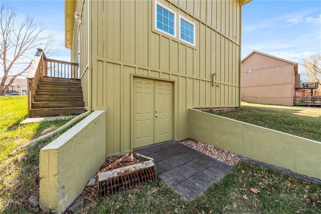 property entrance featuring a yard and board and batten siding