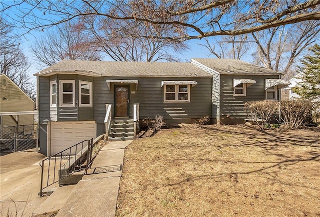 ranch-style home with roof with shingles, concrete driveway, and an attached garage