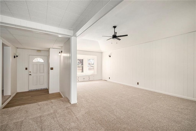 carpeted foyer with baseboards and a ceiling fan