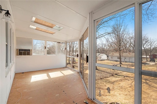 unfurnished sunroom featuring cooling unit, a healthy amount of sunlight, and vaulted ceiling