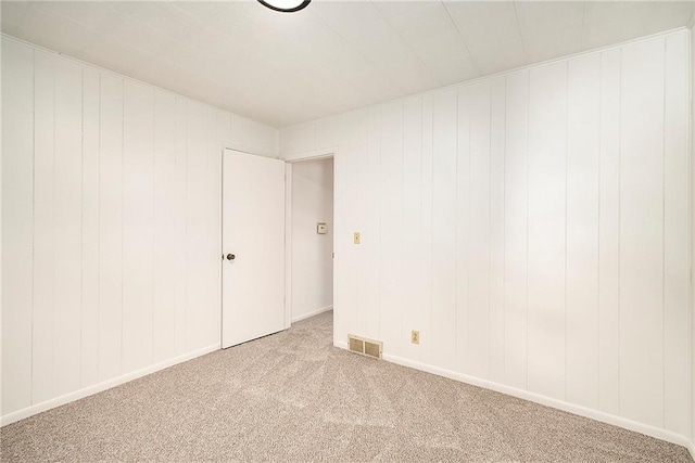 unfurnished room featuring visible vents, baseboards, and light colored carpet