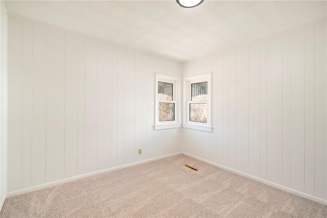 unfurnished room featuring visible vents, light colored carpet, and baseboards