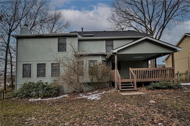 rear view of property featuring a chimney and a wooden deck