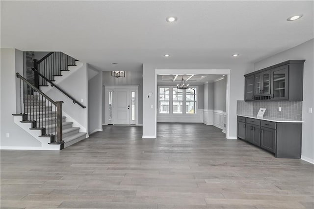 foyer with light wood finished floors, stairway, recessed lighting, and a notable chandelier