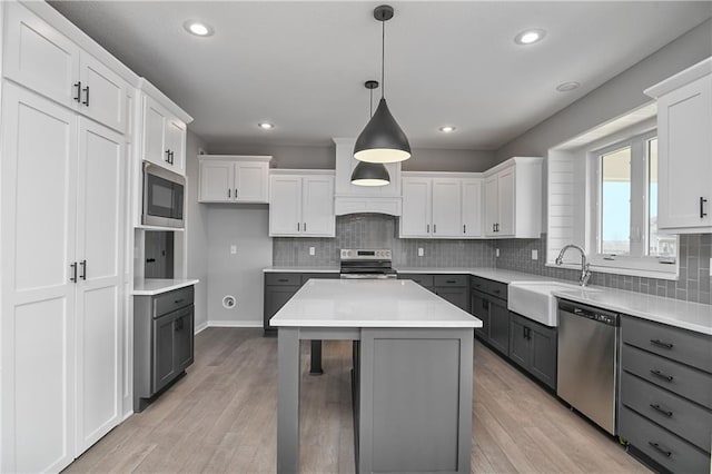 kitchen with a sink, appliances with stainless steel finishes, gray cabinets, and white cabinets