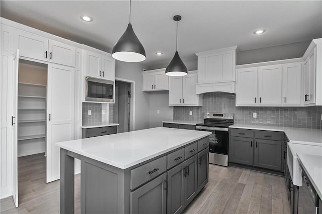 kitchen featuring gray cabinetry, a kitchen island, white cabinetry, appliances with stainless steel finishes, and light wood finished floors