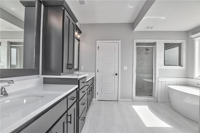 full bath with a freestanding bath, a stall shower, vanity, and visible vents