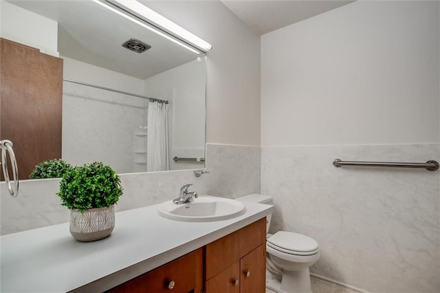 full bathroom featuring a wainscoted wall, visible vents, toilet, tile walls, and vanity