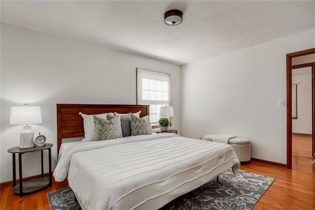 bedroom with baseboards and light wood-style flooring