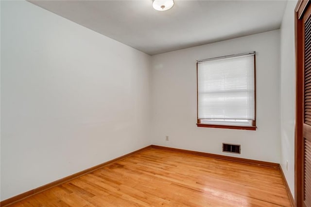 spare room with visible vents, baseboards, and light wood-type flooring