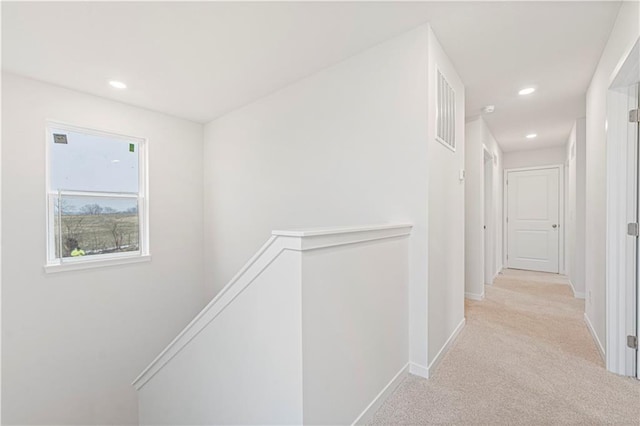 hallway with recessed lighting, carpet, baseboards, and an upstairs landing