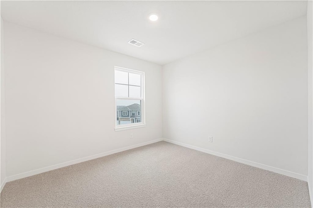 unfurnished room with light carpet, recessed lighting, visible vents, and baseboards