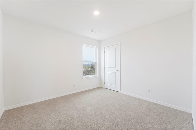unfurnished room featuring light carpet, visible vents, and baseboards