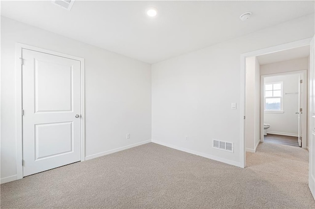 empty room with baseboards, visible vents, and carpet flooring