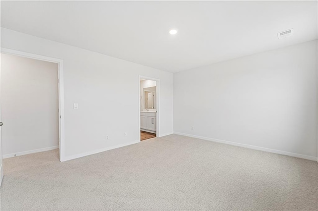 unfurnished bedroom with light carpet, recessed lighting, and baseboards